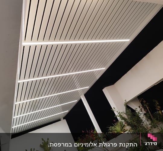 פרגולה מאלומיניום עם תאורה מעל גינה
